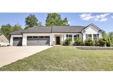 Charming one-story home featuring a three-car garage and landscaped front yard at 42 Voyage Cir, Smithfield, NC 27577