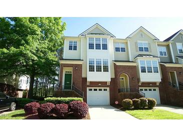 Charming townhome featuring a brick facade, attached garage and colorful landscaping at 4517 Pale Moss Dr, Raleigh, NC 27606
