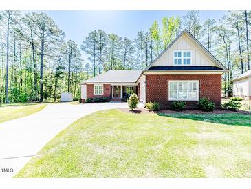 Charming brick home with well-manicured lawn and long driveway on a sunny day at 524 Auguston Ct, Sanford, NC 27330