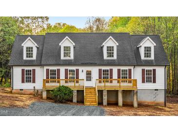 Charming home featuring a covered porch, white siding, a dark gray roof and meticulous landscaping at 580 Greenbriar Farm Trl, Siler City, NC 27344