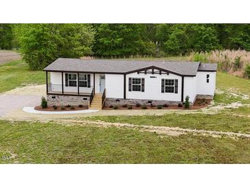 Charming single-story home featuring classic white siding, decorative shutters and a covered front porch at 66 Privette Way, Zebulon, NC 27597