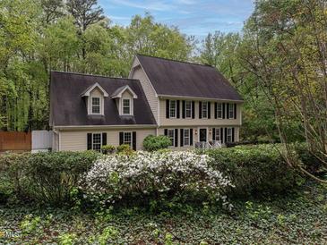 Charming two-story home boasts a lush front yard and classic architectural details at 8805 Stage Ford Rd, Raleigh, NC 27615
