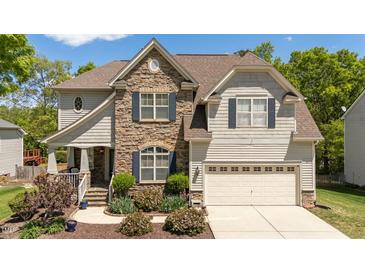 Charming two-story home featuring a stone facade, attached garage, and manicured landscaping at 9212 Linslade Way, Wake Forest, NC 27587