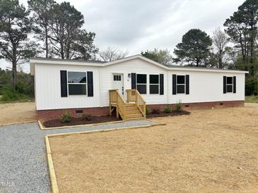 Charming single-story home featuring a white exterior, black shutters, and a landscaped front yard at 10 Riverview Rd, Erwin, NC 28339
