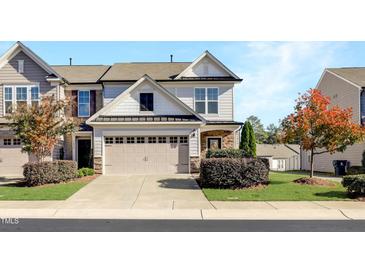 Charming townhouse featuring a two-car garage, stone accents, and well-maintained landscaping at 1016 Mirbeck Ln, Durham, NC 27713