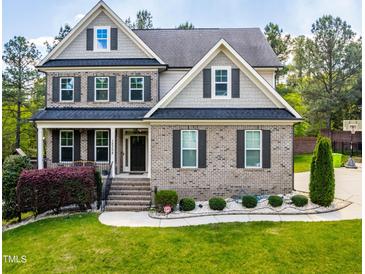 Charming two-story brick home with manicured lawn and mature trees at 12308 Bunchgrass Ln, Raleigh, NC 27614