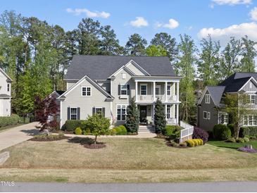 Charming two-story home with a landscaped yard and a welcoming double porch at 1305 Reservoir View Ln, Wake Forest, NC 27587
