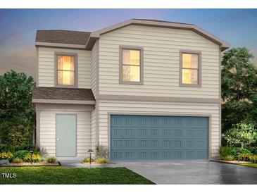 Charming two-story home featuring vinyl siding, a blue garage door, and manicured landscaping at 148 Landon Pl, Roxboro, NC 27573