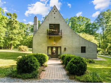 Charming home with unique architecture, front balcony, brick path and mature landscaping, and an inviting entrance at 2509 Nc 57, Hillsborough, NC 27278