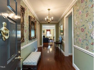 Inviting entryway featuring hardwood floors, floral wallpaper, and a chandelier creating a warm welcome at 2813 Market Bridge Ln # 204, Raleigh, NC 27608