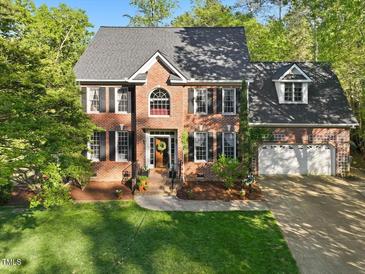 Traditional brick home with a well-manicured lawn, dark shutters, and attached two-car garage at 308 Sunset Creek Cir, Chapel Hill, NC 27516
