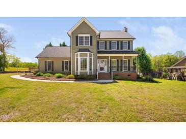 Charming two-story home featuring an inviting front porch and bay window at 4112 Riverport Rd, Raleigh, NC 27616