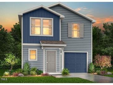 Two-story home featuring blue and gray vinyl siding, well-maintained landscaping, and a covered front entry at 51 Landon Pl, Roxboro, NC 27573