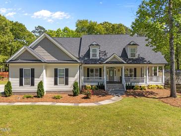 Inviting home with a charming front porch and manicured lawn and neutral color palette at 6907 Field Hill Rd, Raleigh, NC 27603