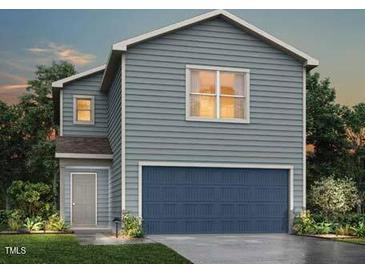 Charming two-story home features a blue garage door, gray siding, and well-maintained landscaping at 76 Landon Pl, Roxboro, NC 27573