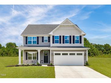 Charming two-story home with gray siding, black shutters, and a well-manicured front lawn at 812 Walker Ridge Way, Willow Springs, NC 27592