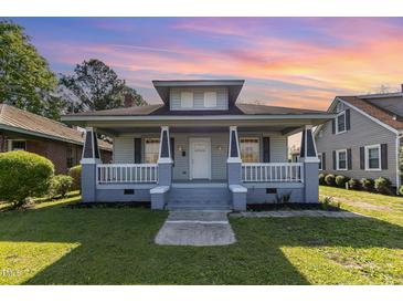 Charming two-story home featuring a welcoming front porch, fresh paint, and a well-maintained lawn at 813 S Franklin St, Rocky Mount, NC 27803