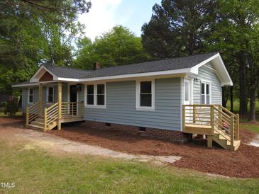 Charming single-story home features light blue siding, a cozy front porch, and a new wooden deck at 1165 John Mitchell Rd, Youngsville, NC 27596