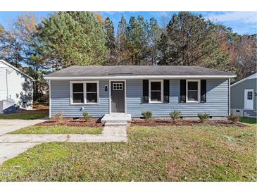 Charming single-story home with blue siding, black shutters, and well-maintained front yard landscaping at 1203 Freeman Dr, Sanford, NC 27330