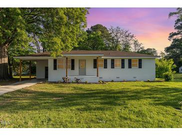 Charming single-story home with white brick and black shutters, complemented by a well-maintained lawn at 124 Strickland Dr, Smithfield, NC 27577