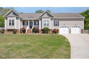 Charming single Gathering home with an attached two car garage, beautiful lawn, and mature landscaping at 1301 Tawny View Ln, Raleigh, NC 27603