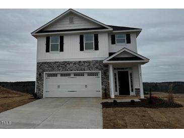 Two story home features a 2-car garage, stone accents, and neutral color palette at 177 Kipling Creek Dr, Fuquay Varina, NC 27526