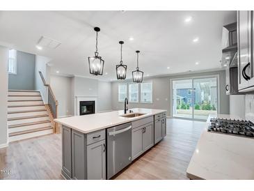Modern kitchen featuring a spacious island, stainless steel appliances, and stylish pendant lighting at 1813 Harrell Cv Ct # 182 Voyageur Fc, Fuquay Varina, NC 27526