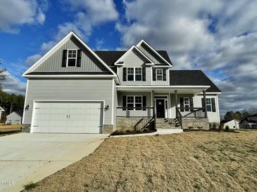 Charming two-story home with a two-car garage, covered porch, and gray siding at 186 Gumtop Dr, Zebulon, NC 27597
