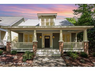 Charming home with a inviting front porch featuring brick accents and a well-manicured garden at 2106 Cloud Cover Ln, Raleigh, NC 27614