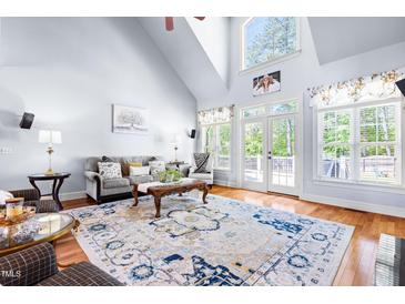 Bright living room boasts vaulted ceilings, a large patterned rug, and french doors to the backyard at 215 Terrell Dr, Rolesville, NC 27571