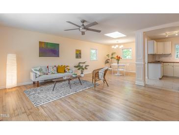 Bright living room features hardwood floors, modern furniture, and stylish decor; a ceiling fan and natural light enhance the space at 2506 N Duke St, Durham, NC 27704