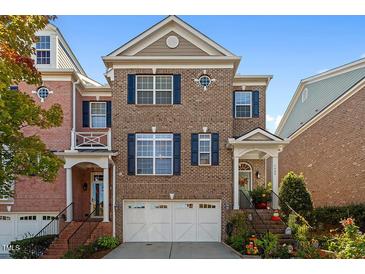Charming brick townhome featuring classic architecture, blue shutters, and a well-maintained front garden at 3009 Weston Green Loop, Cary, NC 27513