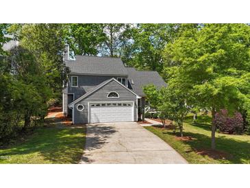 Charming two-story home with attached garage, mature trees, and a concrete driveway at 311 Arlington Rdg, Cary, NC 27513