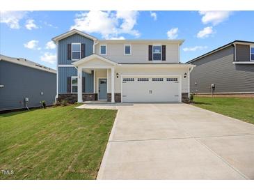 Charming two-story home featuring a welcoming front porch, a two-car garage, and a well-maintained lawn at 708 Deschutes Dr, Garner, NC 27529