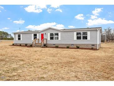 Charming single-story home featuring vinyl siding, white trim and a bright red front door at 7289 Nc 561, Louisburg, NC 27549