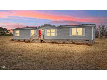 Charming single story home with bright red door and manicured lawn at 7289 Nc 561, Louisburg, NC 27549