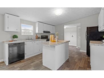 Charming kitchen features an island, neutral countertops, and white cabinets at 7289 Nc 561, Louisburg, NC 27549