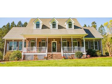 Charming brick home featuring a welcoming front porch and lush green lawn at 7371 Leasburg Rd, Roxboro, NC 27574