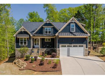 Beautiful craftsman-style home with a well-manicured lawn and inviting front porch at 104 Blue Finch Ct, Youngsville, NC 27596