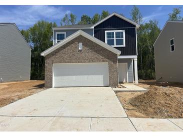New construction home featuring a brick accent over the garage and a two-car driveway at 130 N Keatts Winner Ct, Wilson's Mills, NC 27520
