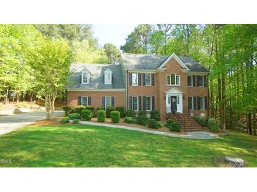 Charming two-story brick home featuring a meticulously landscaped front yard and inviting entrance at 1505 Sharnbrook Ct, Raleigh, NC 27614