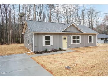 Charming gray home with a gray roof, white trim and yellow door, with a concrete driveway at 156 Southern Middle School Rd, Roxboro, NC 27573