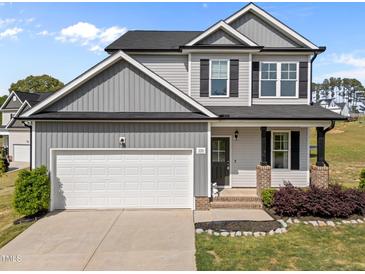 Charming two-story home with a two car garage, landscaped yard and a welcoming front porch at 220 Brisbane Dr, Zebulon, NC 27597