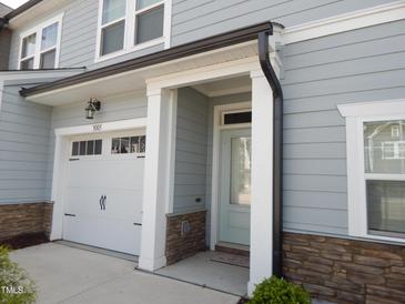 Charming two-story home with a one car garage, stone accents, and light blue siding at 3005 Dunnock Dr, Durham, NC 27713