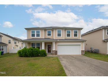 Charming two-story home with a well-maintained lawn, attached two-car garage, and welcoming front porch at 3513 Diamond Springs Dr, Raleigh, NC 27610