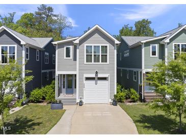 Charming two-story home with a well-manicured lawn, a driveway, and an attached single-car garage at 398 Carolina Ave, Raleigh, NC 27606