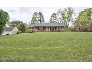 Charming brick ranch with large front yard and mature trees offering curb appeal at 4005 King Charles Rd, Durham, NC 27707