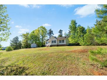 Charming single-story home with a large front yard and a detached storage building at 5860 Andover Dr, Graham, NC 27253