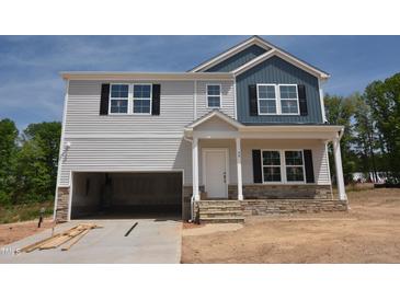Two-story home with light gray siding, blue accent siding, an open garage and stone accents on the facade at 90 Cordoba Dr, Franklinton, NC 27525