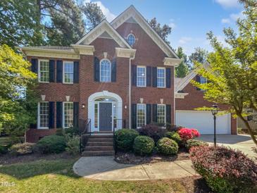 Charming two-story brick home with black shutters and manicured landscaping at 103 Loch Ryan Way, Cary, NC 27513